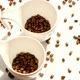 Coffee. Coffee beans in white ceramic cups and falling coffee beans. - VideoHive Item for Sale