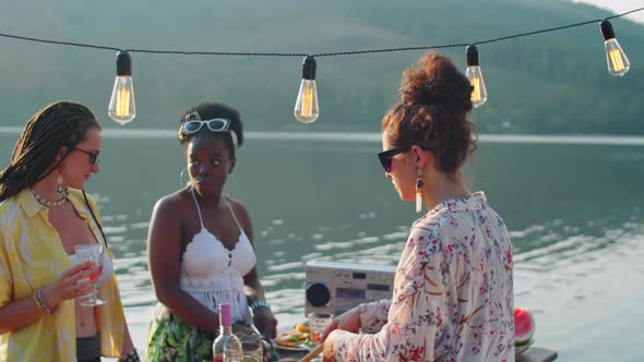 Girls Cooking Food for Outdoor Party on Lake Pier