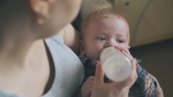Mommy Feeds Tired Baby with Fresh Milk in Light Room