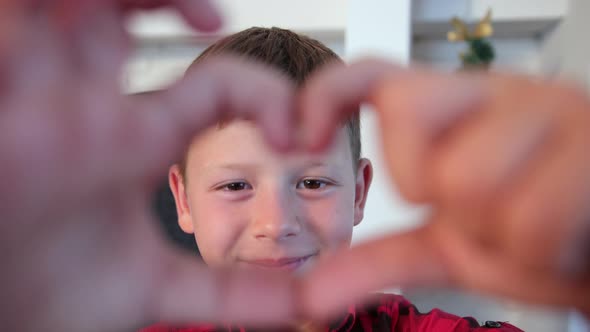 Portrait of Happy Boy with a Heart Shape Made By Hands