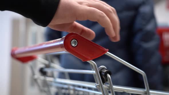 A Man With a Shopping Cart Is Standing in Line at the Store's Checkout and Nervously Taps Her