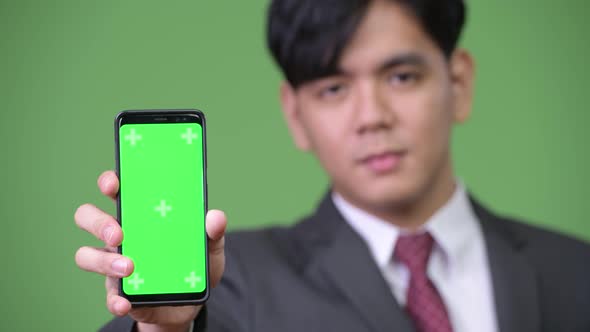 Young Handsome Asian Businessman Showing Mobile Phone