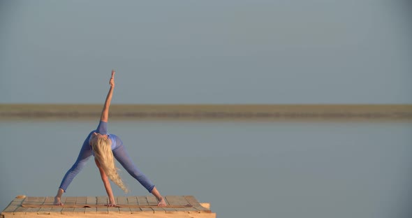 Exercising Young Woman in the Middle of the Lake During Sunset