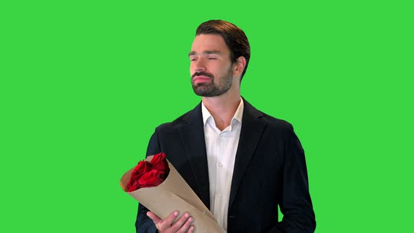 A Young Man in a Suit Holding a Bouquet of Red Flowers and Waiting for Someone on a Green Screen