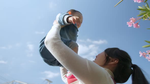 Happy asian family. A mother plays with her young son in the Park at daytime