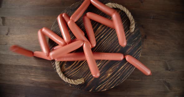 Boiled Sausages Fall on the Wooden Tray
