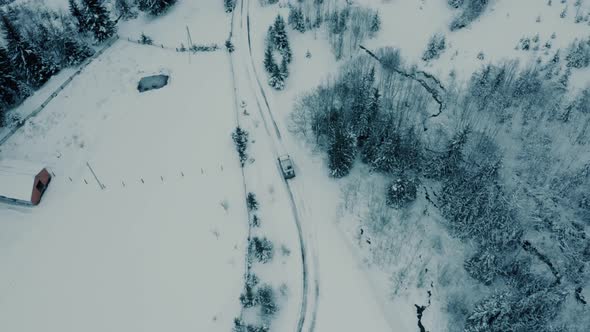 Winter Aerial Footage of a Curved Windy Road Village Cutting Through Mountains Landscape