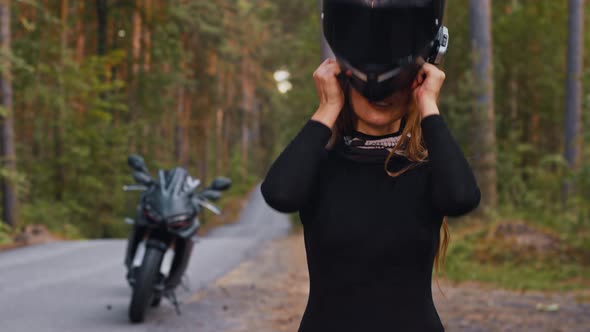 Adult Woman Motorbike Rider Putting on Her Helmet and Looking in the Camera