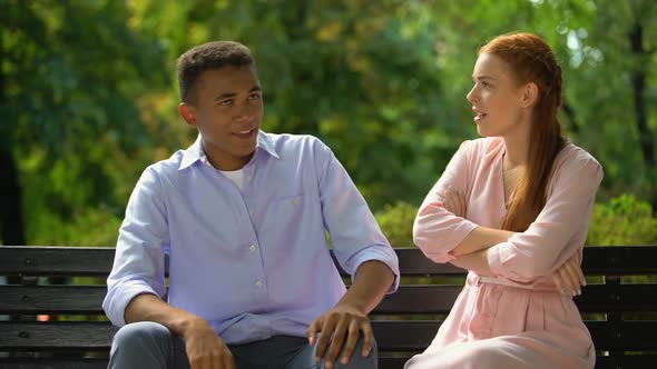 Multiethnic Couple Arguing Sitting on Bench in Park, Jealousy, Misunderstanding