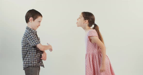 Brother and sister arguing and fighting on a white studio background