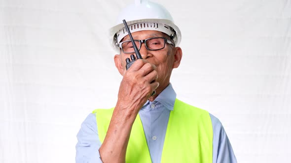 Senior architect engineering builder wearing safety vest and helmet using walkie-talkie talks about