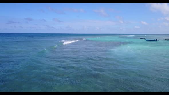 Aerial top down seascape of marine resort beach vacation by shallow lagoon with white sandy backgrou