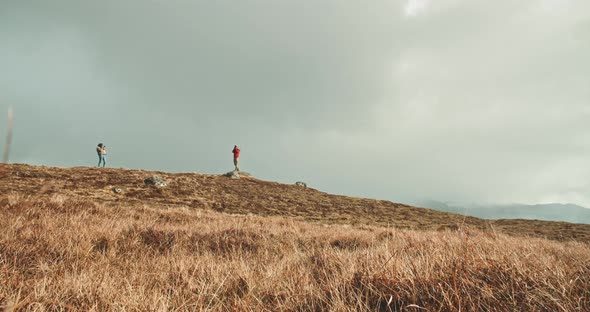 Two photographers taking pictures of themselves on a hill