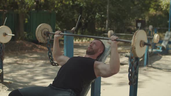 Fit Man Doing Barbell Incline Bench Press Outdoors