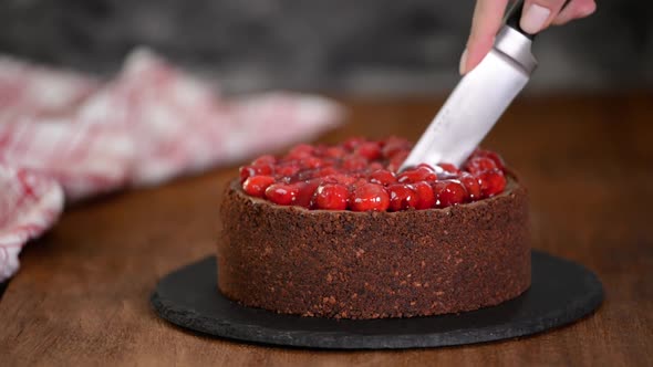 Female hands cutting chocolate cheesecake with a knife. Homemade sweet dessert.	
