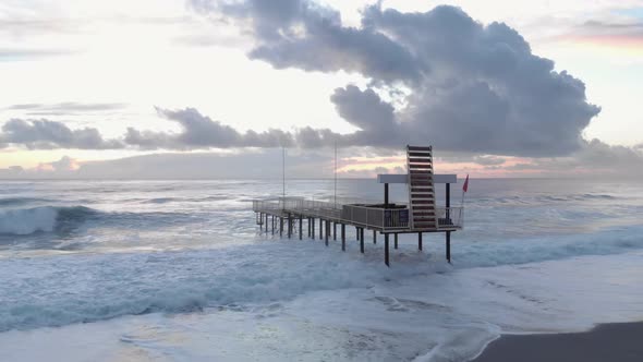 Huge sea waves crashing on empty pier.