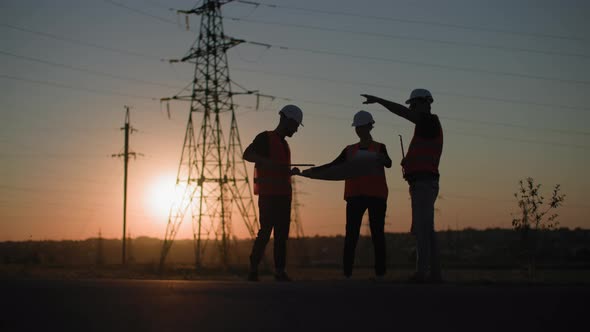 Electric Industry Professional Male and Female Engineers Discuss New Power Grid Project Against