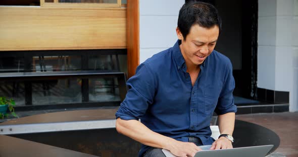 Man Using Laptop at Outdoor Cafe 4k