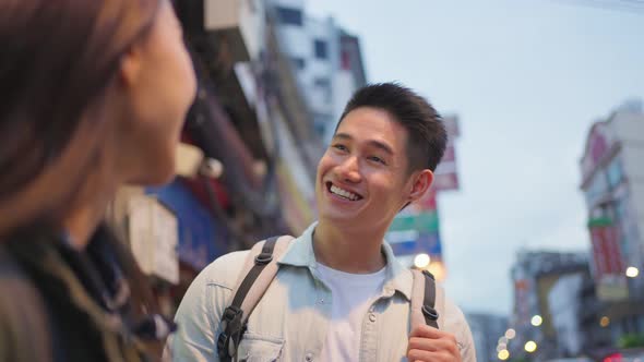 Asian active young couple travel in city for honeymoon trip at night.