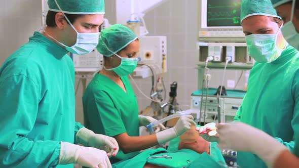 Side view of a surgical team next to a patient