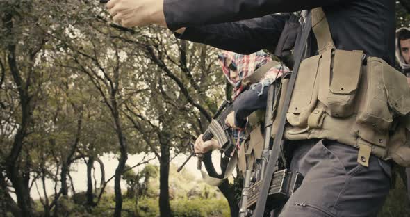 Squad of armed terrorists patrolling a forest area during combat