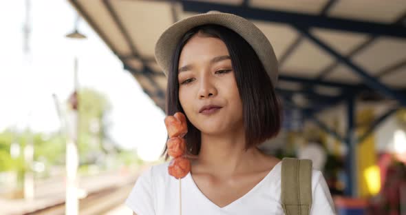 Woman eating sausage and looking at camera