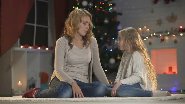 Cute Girl Missing Father and Hugging Mom, Sitting Near Beautiful X-Mas Tree