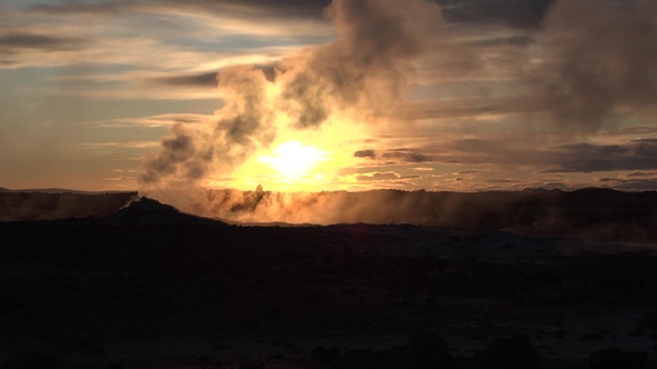 Geothermal region area valley with smoking fumaroles and hot streaming water from geysers.