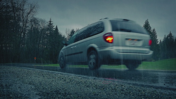 Car Passes In Heavy Rain In Wooded Area