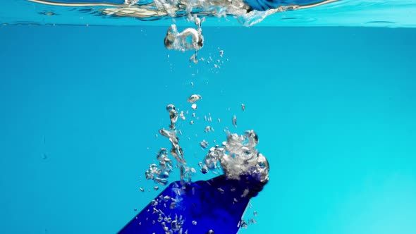 Closeup of Sinking Plastic Bottle in Ocean Throwing Garbage Into the River or Lake Water Pollution