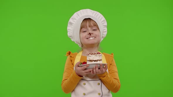 Child Girl Kid Dressed As Professional Cook Chef Showing Eating Tasty Handmade Strawberry Cake