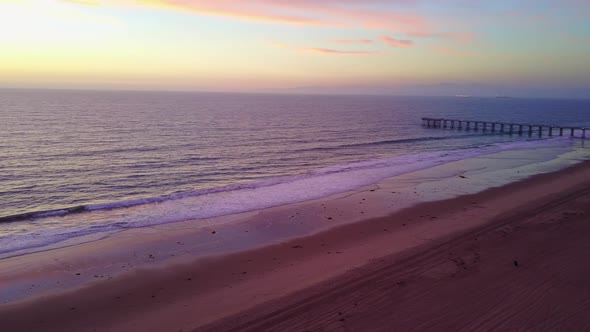 Aerial drone view of a sunset at the beach over the ocean.