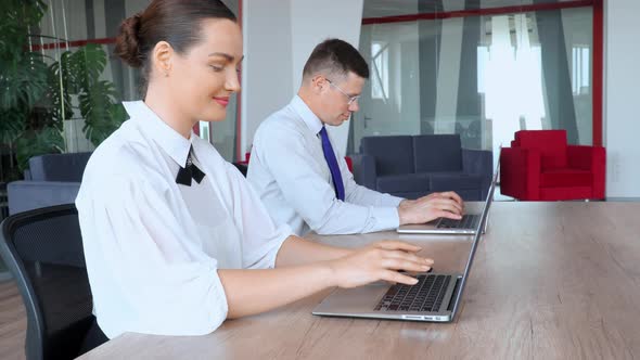 Businessman and Businesswoman Working with Laptop