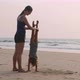 Young Sporty mother with little daughter doing gymnastic on the beach. - VideoHive Item for Sale