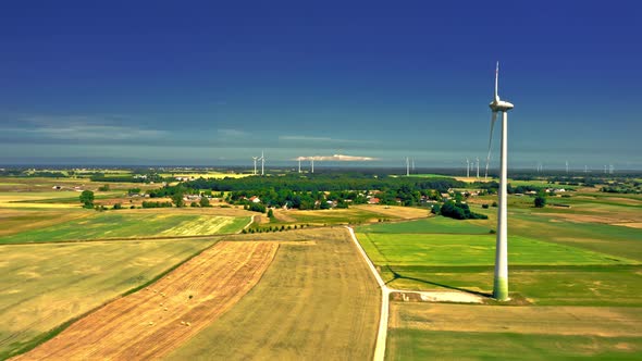 Wind turbine on field before harvest. Agriculture in Poland.