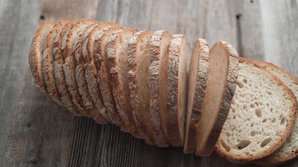 Sliced sourdough bread falling on a table. Slow Motion.