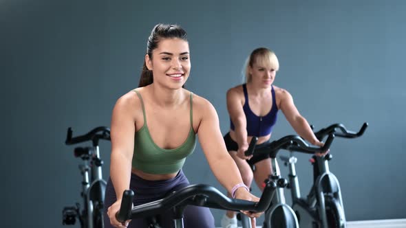 Athletic Woman Spinning Pedals of Exercise Bike Enjoying Cardio