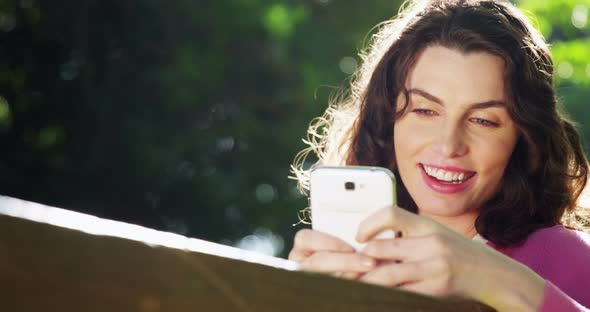 Beautiful woman using mobile phone in park