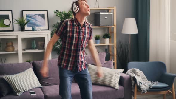 Carefree Student Is Dancing and Singing Listening To Music Through Headphones Relaxing at Home