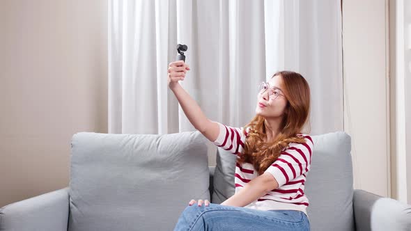 Girl doing vlog in her house holding camera in hand.