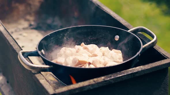 Close-up, Slow Motion: Pork Meat Is Fried in Saucepan on Charcoal