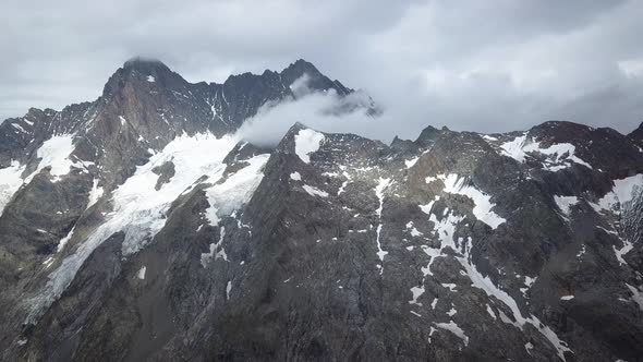 Travelling of the majestic Schreckhorn peak in the swiss alps mountain range in a cloudy and scary d