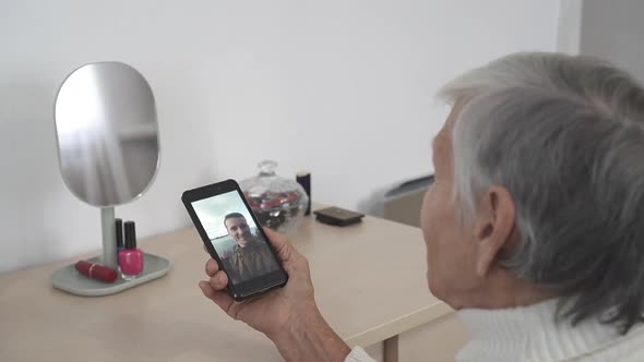 Old woman having video chat using smartphone