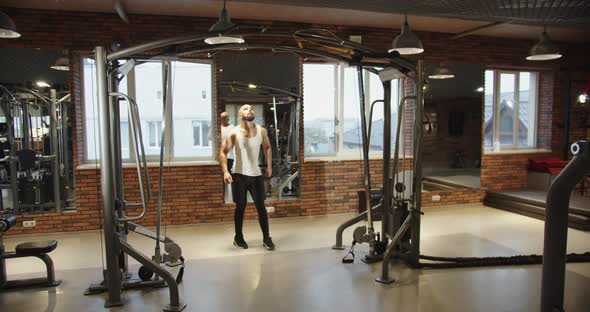 A Young Athlete Walks Across the Gym to the Pullup Bar