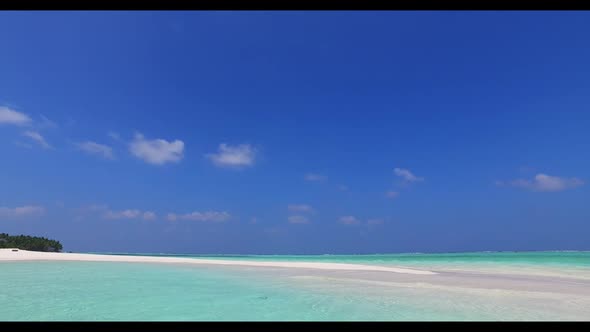 Aerial landscape of idyllic tourist beach lifestyle by blue ocean with white sandy background of a d