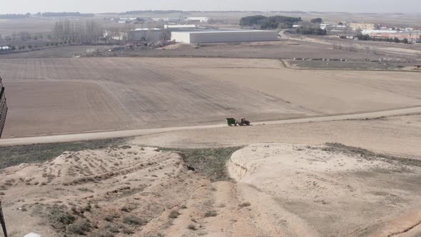 From above tractor with trailer near fields