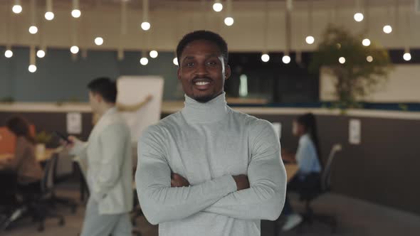 Young African American Handsome Businessman Looking at the Camera Standing in Modern Office with