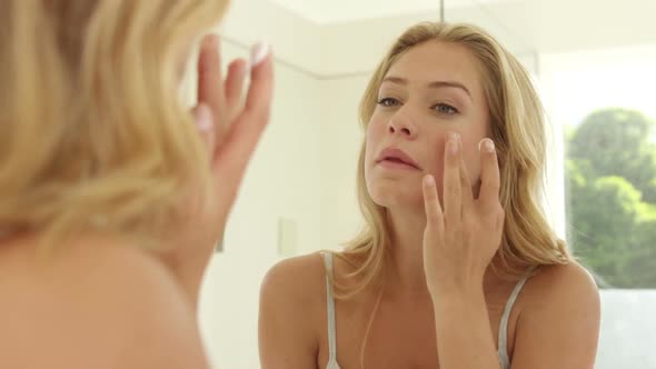 Young Woman Applying Cream on her Face