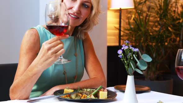 Smiling mature woman drinking red wine