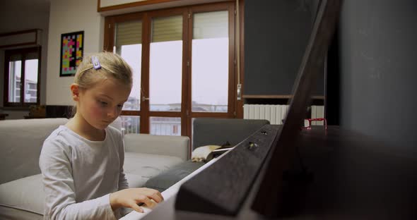 Little Girl Playing Piano at Home. Kid Play Piano in Living Room. Child Learning Piano at Home